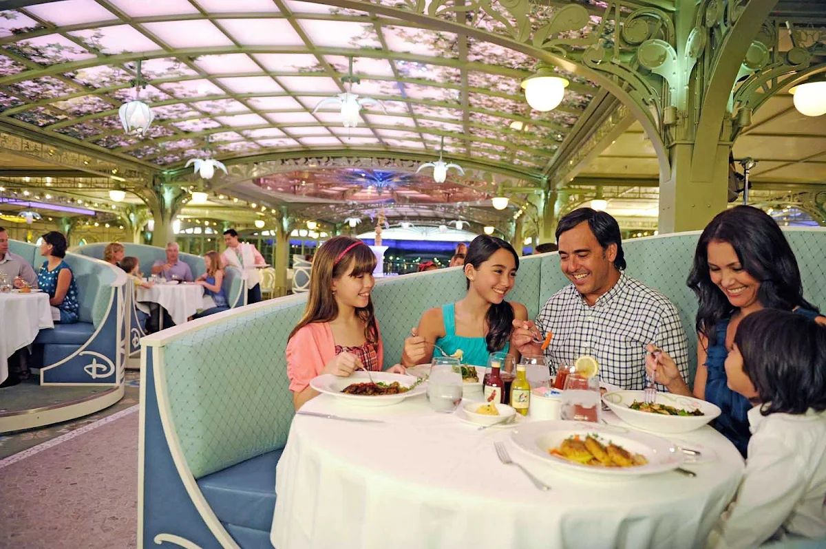 Disney-Cruise-Line-Enchanted-Garden-Family-in-booth - Enchanted Garden is one of three rotational main dining restaurants on the Disney Dream and Disney Fantasy. It's open for breakfast, lunch and dinner.  