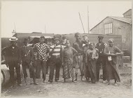 Indonesische mannen en vrouwen, op de achtergrond Europese mannen, vermoedelijk op een haventerrein