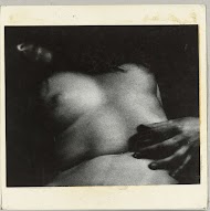 Borst en buik van een liggende, naakte vrouw met de linker hand op haar buik