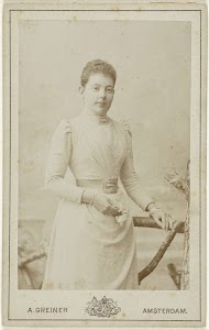 Studioportret van een jonge vrouw in hooggesloten jurk met pofmouwen