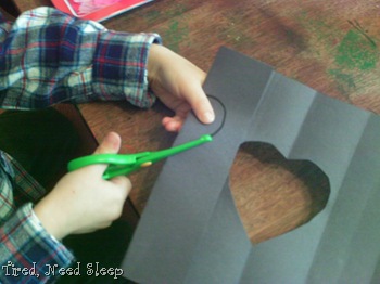 M cutting out hearts on folded lines