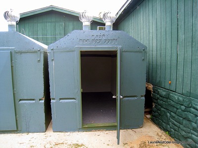 Solid concrete tornado shelter has a heavy metal door.