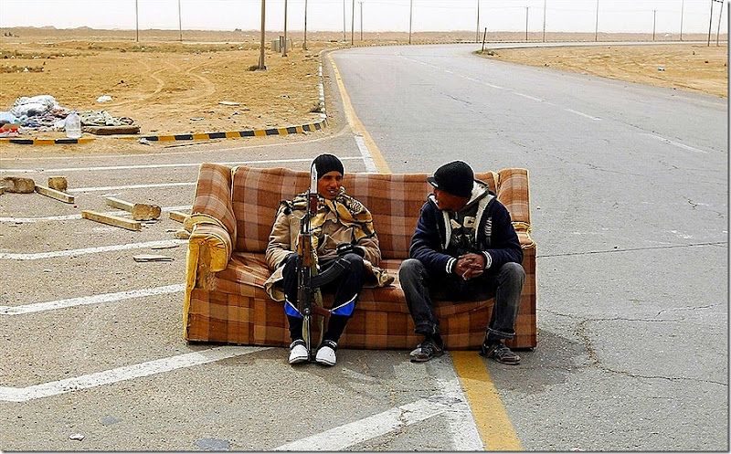 Rebel fighters sit on a sofa at a check point in Ajdabiyah, March 15, 2011. (GORAN TOMASEVIC, Reuters)