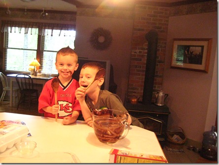 Austin and Dakota grinning as they eat the brownie batter