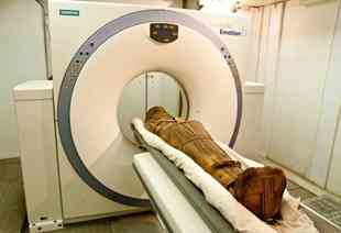 An ancient mummy is loaded into a CT scanner at the National Museum of Antiquities in Cairo
