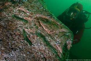 A diver inspects a quartzite block with an engraving of a Pharaoh, indicated by hieroglyphic inscriptions on the stone as Seti I, on the seabed of the harbor of Alexandria