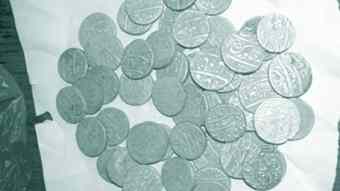 Local contractor excavates a pot of Mughal era silver coins