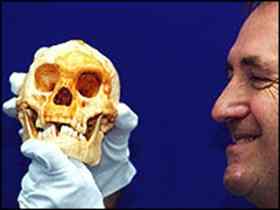 Chris Stringer holds a cast of the 18,000-year-old hominid LB1