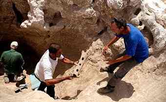 Uzi Ad, excavation director, holding one of findings 