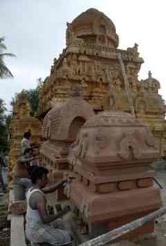 Masons working on the restored vimana of the temple.