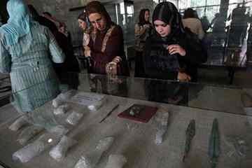 Iraqi women look at historical artefacts that had been stolen after the US invasion of Iraq in 2003 and then recovered