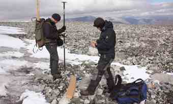 Norwegian archaeologists Trond Vihovde, left, and Elling Utvik Wammer use a GPS marker to register the location of sticks used in reindeer hunting from before the Viking Age. Photograph: Alister Doyle/Reuters