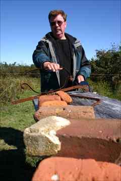 Brian Harding shows artifacts recovered from Fort Point, including bricks that likely came from chimneys of buildings in the fort. 