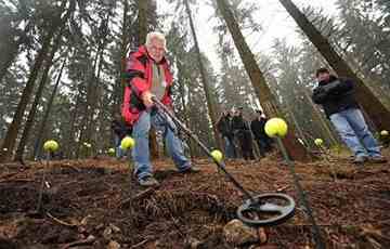 The battlefield is located on top of a wooded hill. The poles with tennis balls stuck on them show where artifacts were found.