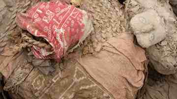 Two funerary bales, allegedly wrapping the remains of an adult, left, and a child from the Wari culture, sit inside a tomb at a pyramid called Huaca Pucllana in Lima, Peru. Picture: AP Photo/Karel Navarro  Source: AP