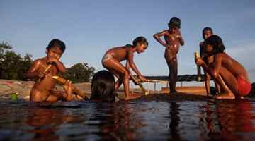Children eat sugar cane and play in Brazil's Rio Negro, whose water level fell recently to reveal stone age etchings. Photograph: Ricardo Moraes/Reuters