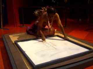 Vanuatuan artist Edgar Hinge creating a sand drawing of a turtle at Quai Branly Museum in Paris [Photo: Laura Angela Bagnetto]
