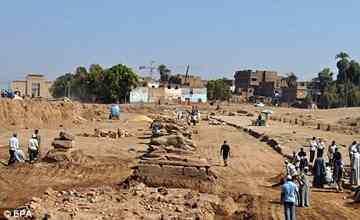 Workers remove some of the earth along the newly discovered road in Luxor.