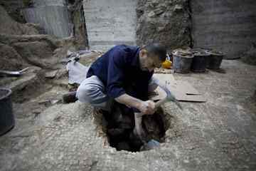 A worker of the Israel Antiquities Authority works at an excavation site in Jerusalem's Old City Monday. Israeli archaeologists preparing the ground for a new Jewish ritual bath in Jerusalem's Old City say they have made a coincidental discovery, an 1,800-year-old swimming pool built by the same Roman legion that destroyed the ancient city's hallowed second Jewish Temple. (Bernat Armangue, Associated Press)