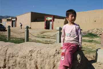 A child from Zhelaizhai sits on the town's 'Roman Wall' (Courtesy of Prof. Chen Zhengyi, History Dept., Lanzhou University, China)