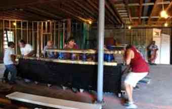 Work crews move a piece of a pirate ship inside a building being renovated to house the new Pirate and Treasure Museum.
