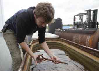 John Albertson, 27, a grad student studying nautical archaeology at Texas A&M Riverside Campus, displays one of the million artifacts from Lasalle's flagship La Belle, which was pulled from the Matagorda Bay by archaeologists in 1995.