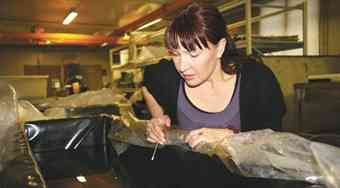 Women looking Marine archaeologist Riikka Alvik shows off a piece of the wreck of Vrouw Maria, which sits in liquid plastic at the Finnish Maritime Museum in Helsinki.