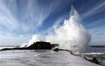 A wave crashes into what remains of the breakwater at the outer part of the port of Caesarea Photo: EPA