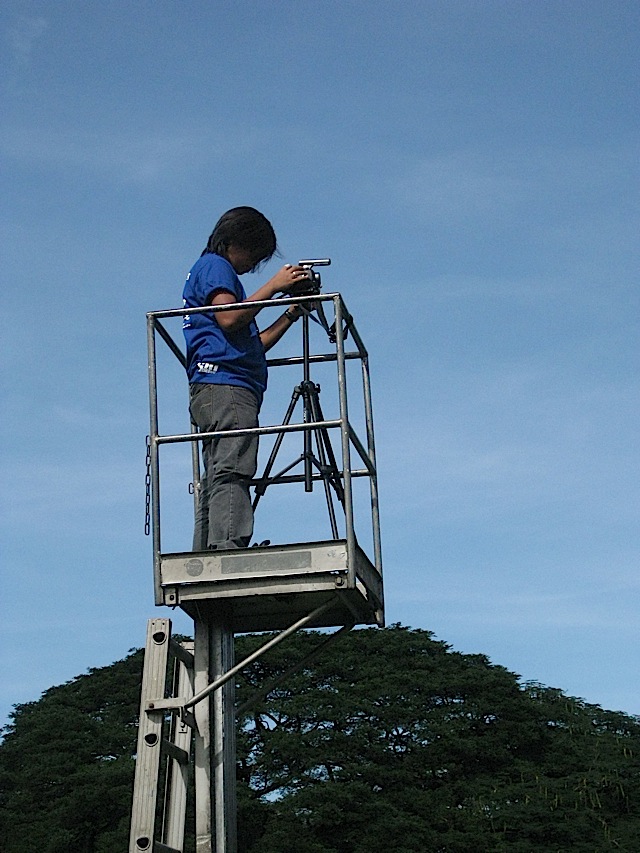 recording an event from a small platform attached to the top of a ladder