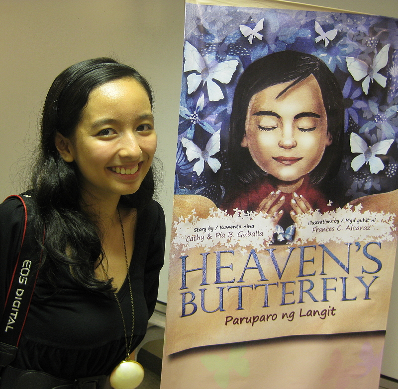 Pia Guballa with a banner of her book 'Heaven's Butterfly'