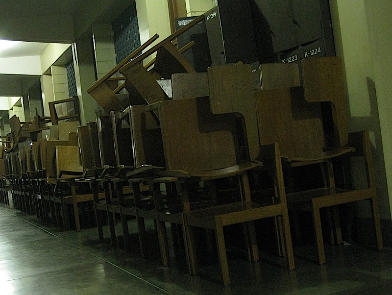 stacks of school chairs outside a classroom