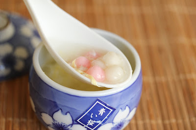 a scoop of rice wine soup made with homemade fermented rice in a white spoon