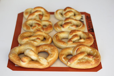 soft pretzels lined up on a baking mat.