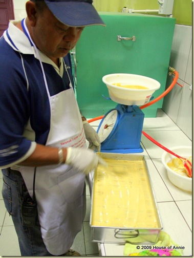 spreading out batter for top layer of sarawak layer cake - copyright house of annie