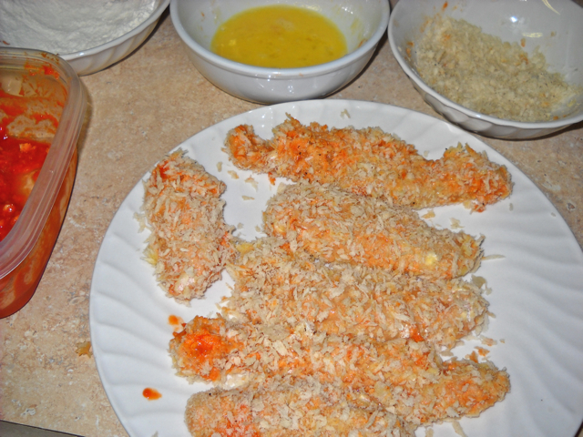 Sriracha Panko breaded chicken strips out of breading station and ready to bake 