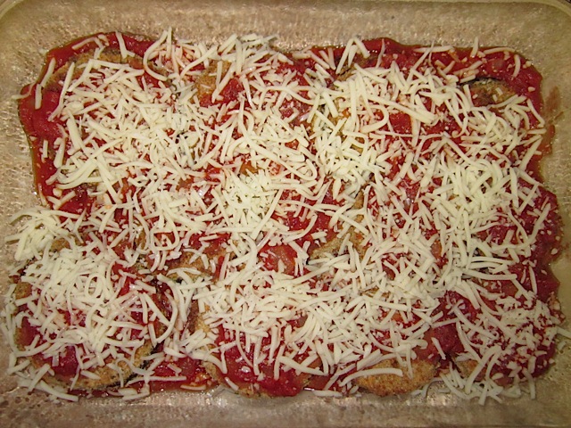 eggplant parmesan layer two - sauce in bottom of pan, layer of eggplant, another layer of sauce and shredded cheese on top
