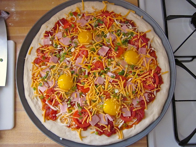 Eggs added to pizza, ready to. bake 