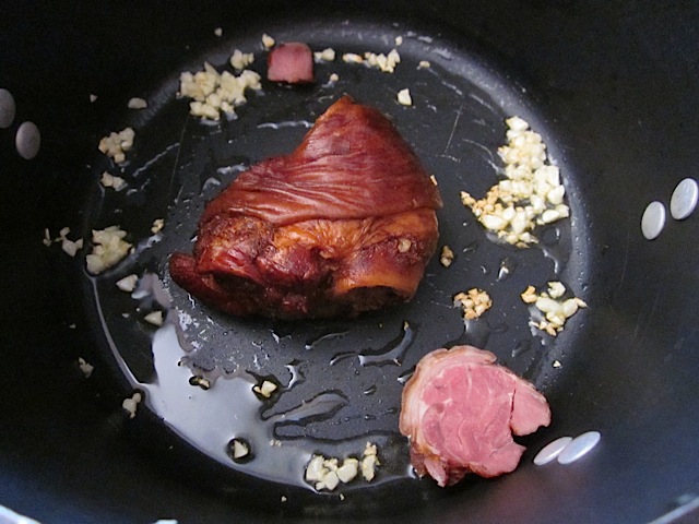 ham hock, chicken broth and garlic in pan