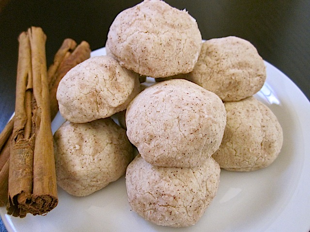 Polvorones on white plate with cinnamon sticks on the side