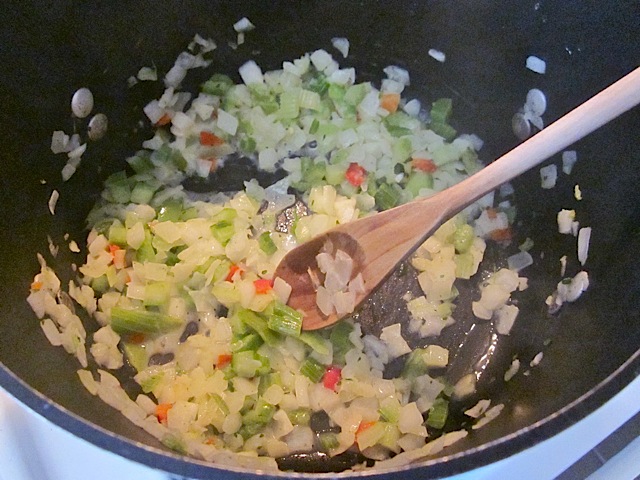 seasoning blend in pot being cooked with wooden spoon 