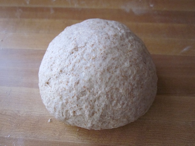 kneaded and shaped dough ball on counter top 
