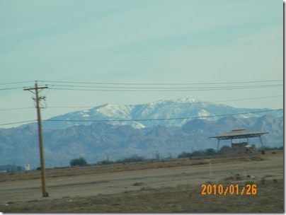 snow on the mountains past Coolidge with the Casa Grande Ruins in the foreground