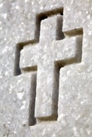 Cross carved into a veteran's headstone. Memorial to fallen soldier carved into granite