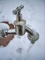 frozen faucet with the ice and snow in background