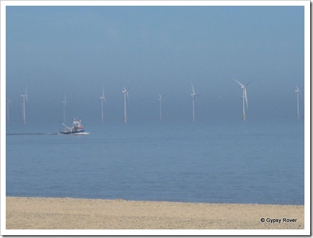 A fishing boat heads back to port past the wind farm off great Yarmouth.