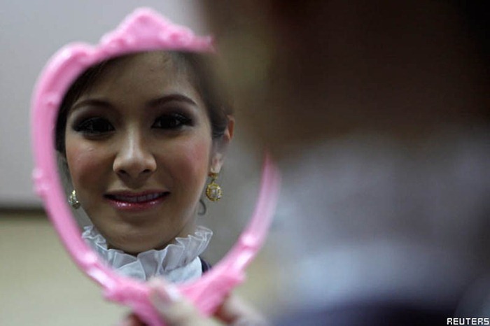 Transsexual flight attendant  Dissanai Chitpraphachin, 24, looks at herself in a mirror is during a make-up training session at PC Air office in Bangkok February 9, 2011. A newly formed Thai airline PC Air wants to make a different from their competitors by hiring the transsexual flight attendants. Be pretty and be feminine are the qualification the ladyboys should have to join a new charter airline that will begin the operation in early April. The airline has recruited four ladyboys, 19 female and seven male but said they will need to employ more of transsexual on their flights in the future.  REUTERS/CHaiwat Subprasom (THAILAND - Tags: SOCIETY TRANSPORT)