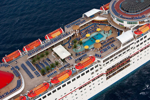 Relax with a book and a cool drink under the palm trees at Carnival Sensation's main pool area.