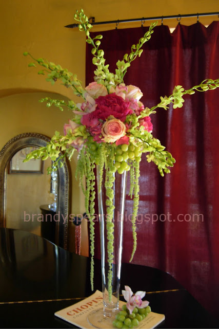 tall wedding centerpiece in pinks of hanging grapes, amaranthus, roses, hydrangea, orchids