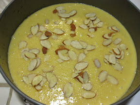 photo of of the cake batter in a pan with almond slices scattered on top