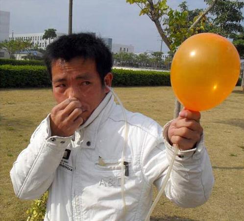 Chinês enche balões com o ouvido
